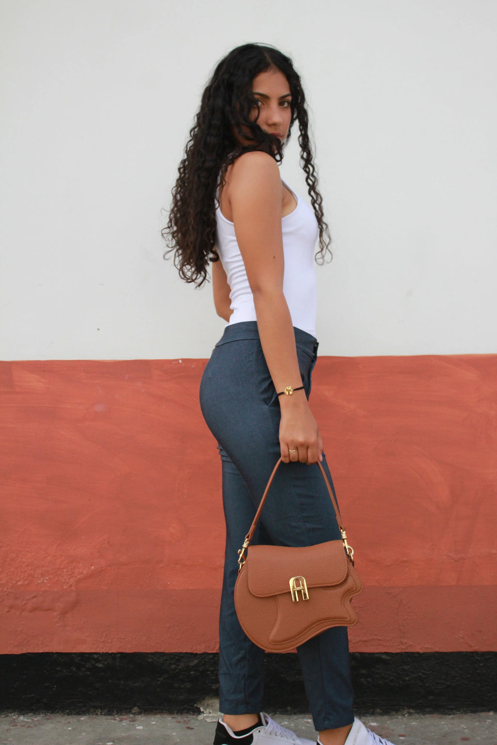 Woman holding a brown handbag on a red and white background